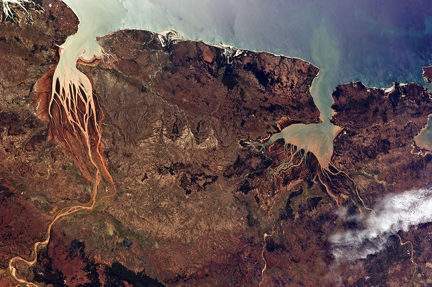 Estuaries – where the waters of seas and rivers mix – on the northwestern coast of Madagascar, a large African island in the Indian Ocean. The Mozambique Channel (top) separates Madagascar from the southeastern coast of Africa. The Betsiboka River, which flows into Bombetoka Bay (upper left), leaves striking red floodplain sediments. Mahajamba Bay (right) is fed by several rivers including the Mahajamba and Sofia. Like the Betsiboka, the floodplains of these rivers contain reddish sediments eroded from their basins upstream. (Nasa, CC BY-NC 2.0)