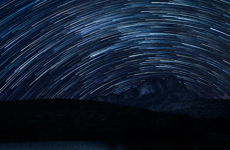 Star trails curve over the massif of the Waterberg Mountains in a time-lapse night shot taken from the Tlopi Tented Camp in Marakele National Park, Limpopo province. The surface of Tlopi Dam can be seen in the foreground. (Martin Heigan, CC BY-NC-ND 2.10) Martin Heigan mh@icon.co.za http:\anti-matter-3d.com http:\www.flickr.comphotosmartin_heigan