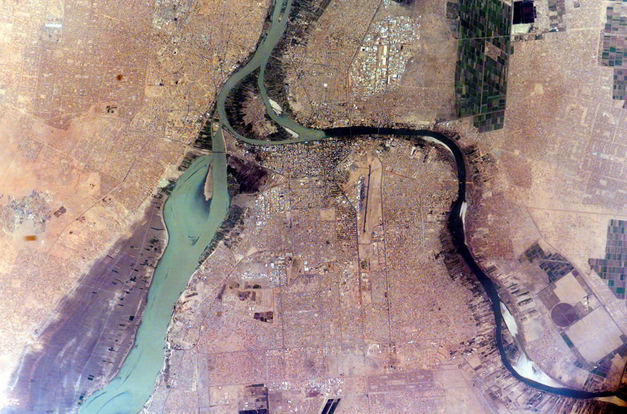 The White Nile and Blue Nile rivers meet in the city of Khartoum, the capital of Sudan. Here they form the great Nile River, which then flows north through Egypt to Cairo and empties into the Mediterranean Sea. In this image taken in the 2005 dry season, the still-flowing White Nile is at left, and the nearly dry Blue Nile curves at right. The source of the White Nile, near the equator in Uganda, produces a nearly constant flow throughout the year. The Blue Nile, by contrast, rises from the highlands of Ethiopia where it is fed by the rainfall of summer monsoons, producing floods in autumn but drying out in the spring. (Nasa, CC BY-NC 2.0)